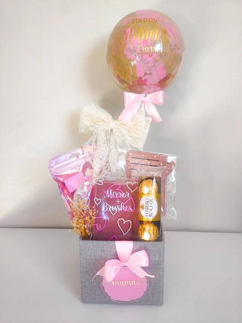 Personalised bubble balloon above a gift box of chocolates and treats with pink ribbon