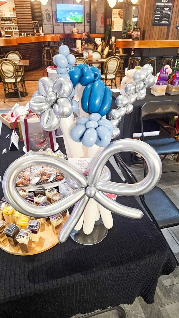 Silver and blue balloon flower bouquet with a twisted balloon bow