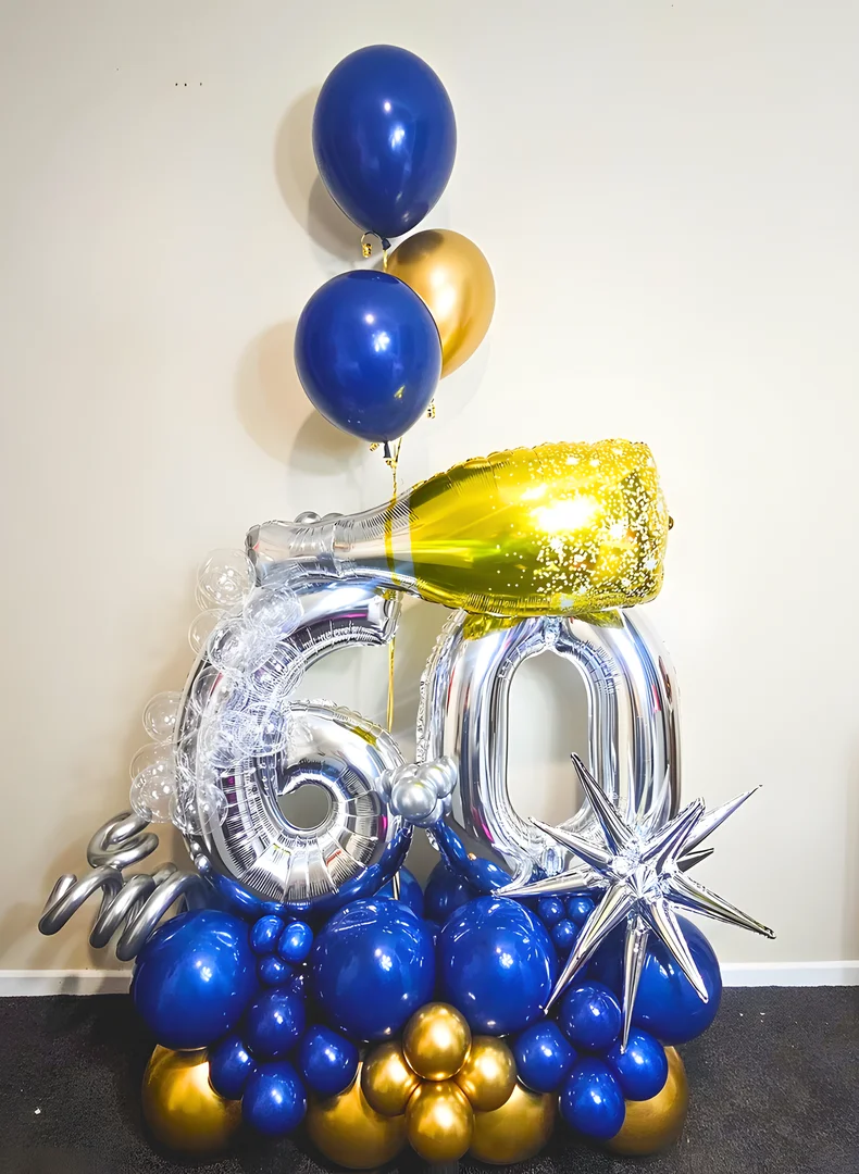 Silver 60 foil numbers with a personalised gold champagne bottle balloon, bubble details, a gold starburst and navy and gold helium balloons