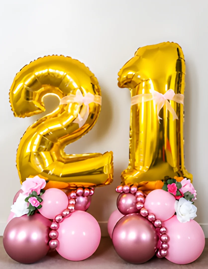 Gold 2 and 1 foil numbers on two pink balloon bases decorated with pearl balloon strands, ribbons and artificial roses