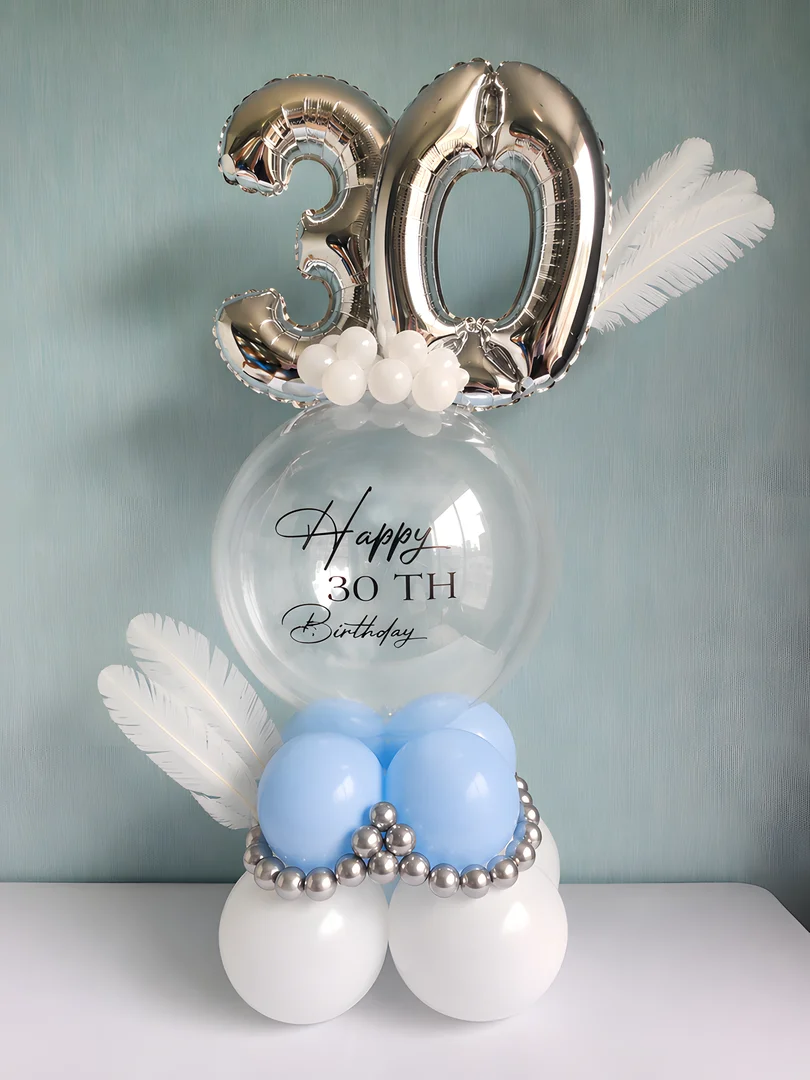 Silver 30 foil numbers above a Happy 30th Birthday bubble balloon with white feathers and blue and white balloons