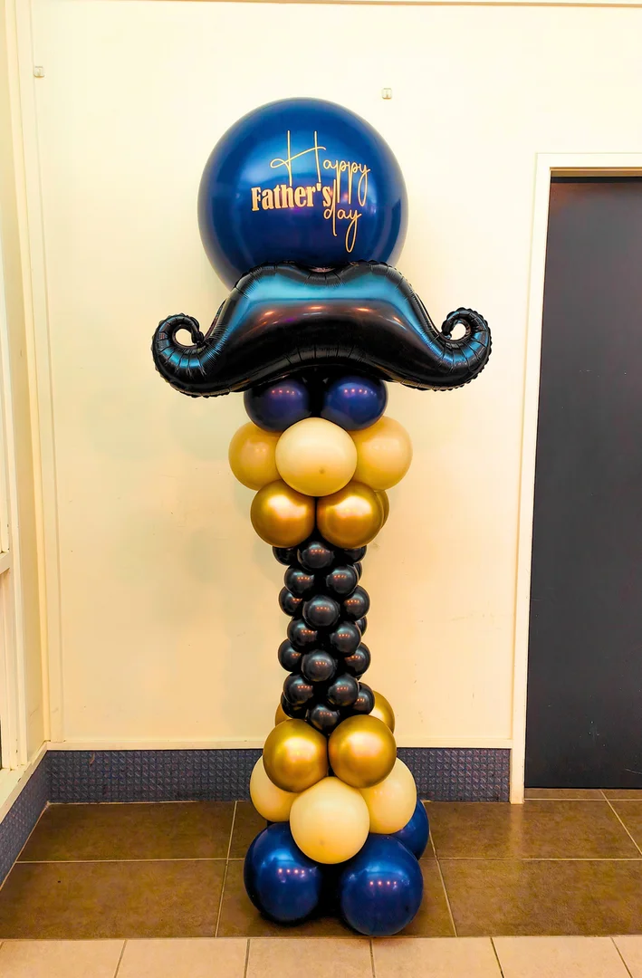 Navy Happy Father's Day balloon with a black moustache foil balloon on a navy, gold and cream balloon column