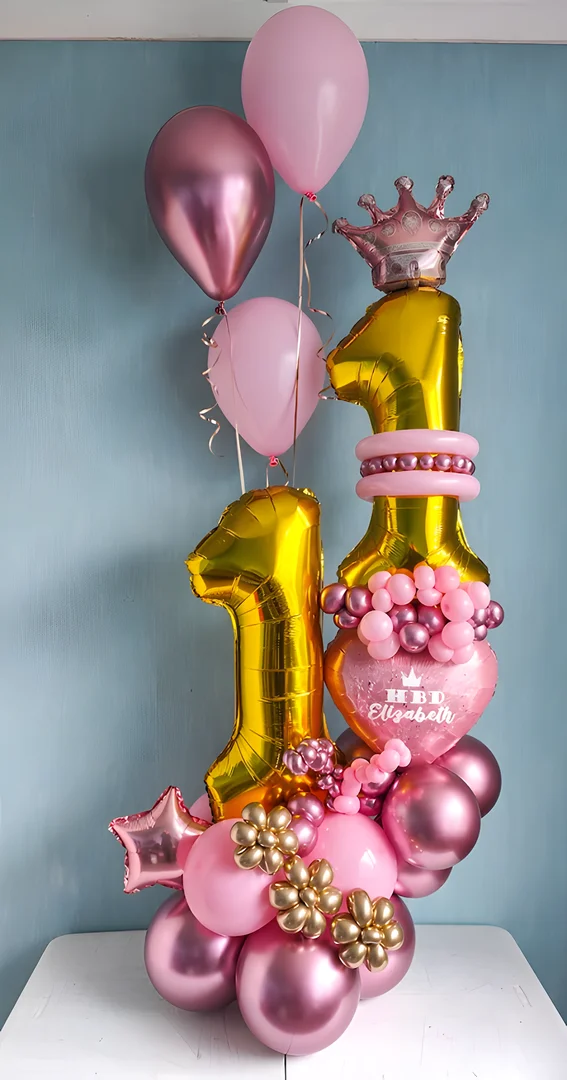 Gold 11 foil numbers with a crown topper, a personalised pink heart balloon, gold balloon flowers and pink helium balloons